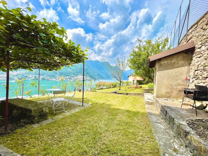 Garden with barbecue and stone wall above the lake